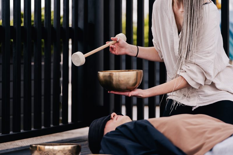 Therapist performing a Tibetan singing bowl massage